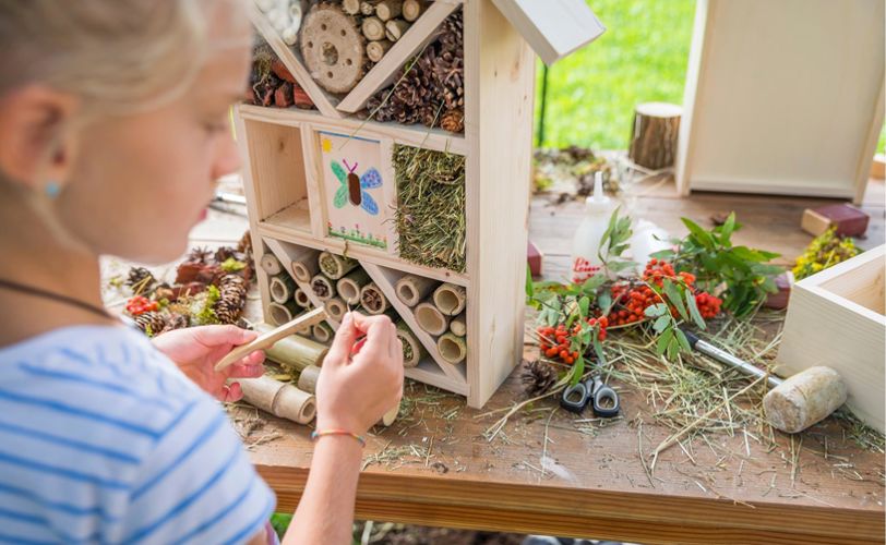 Una bambina costruisce una casetta per insetti