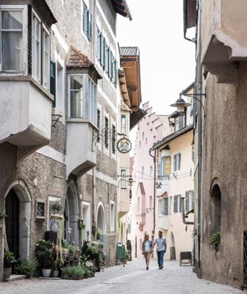 A couple is strolling through the historic city centre of Klausen