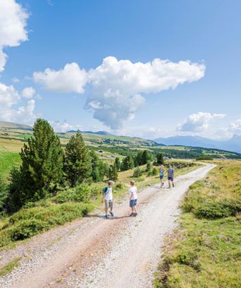 A family is hiking on the Villanders mountain pasture