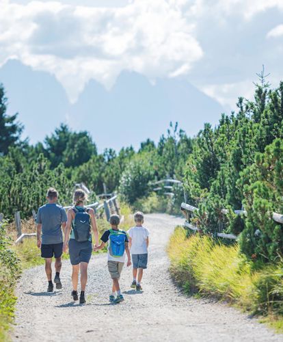 A family is hiking on the Villanders mountain pasture