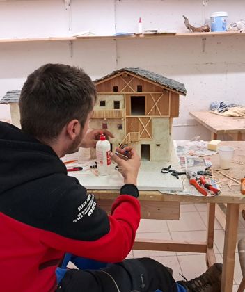Un uomo costruisce un presepe