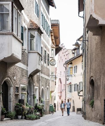 A couple is strolling through the historic city centre of Klausen