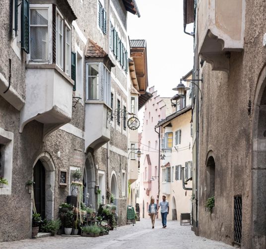 A couple is strolling through the historic city centre of Klausen