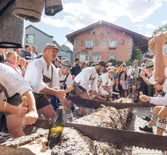 Uomini che tagliano un tronco di legno