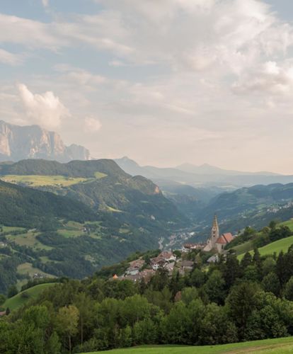 Vista su Villandro e le montagne in estate