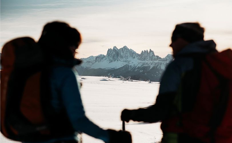 Zwei Personen genießen das winterliche Panorama