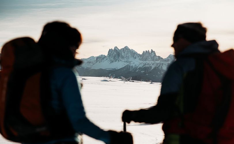 Zwei Personen genießen das winterliche Panorama