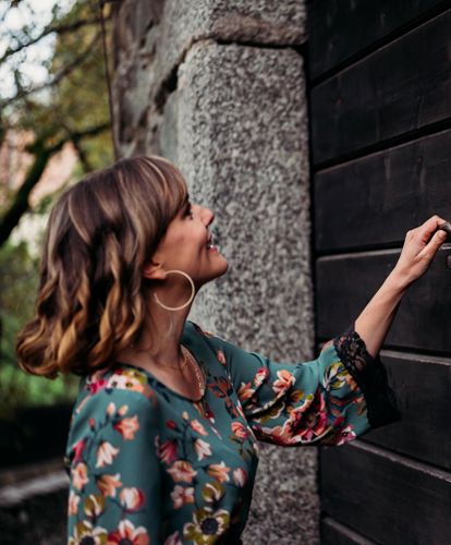 A woman opens an old door