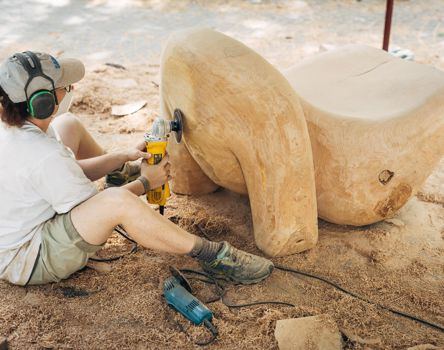 A wood carver is polishing something